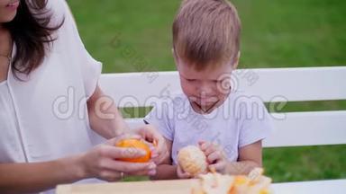 夏天，在花园里。 妈妈和四岁的儿子从橘子皮中清洗。 他们想做新<strong>鲜果汁</strong>